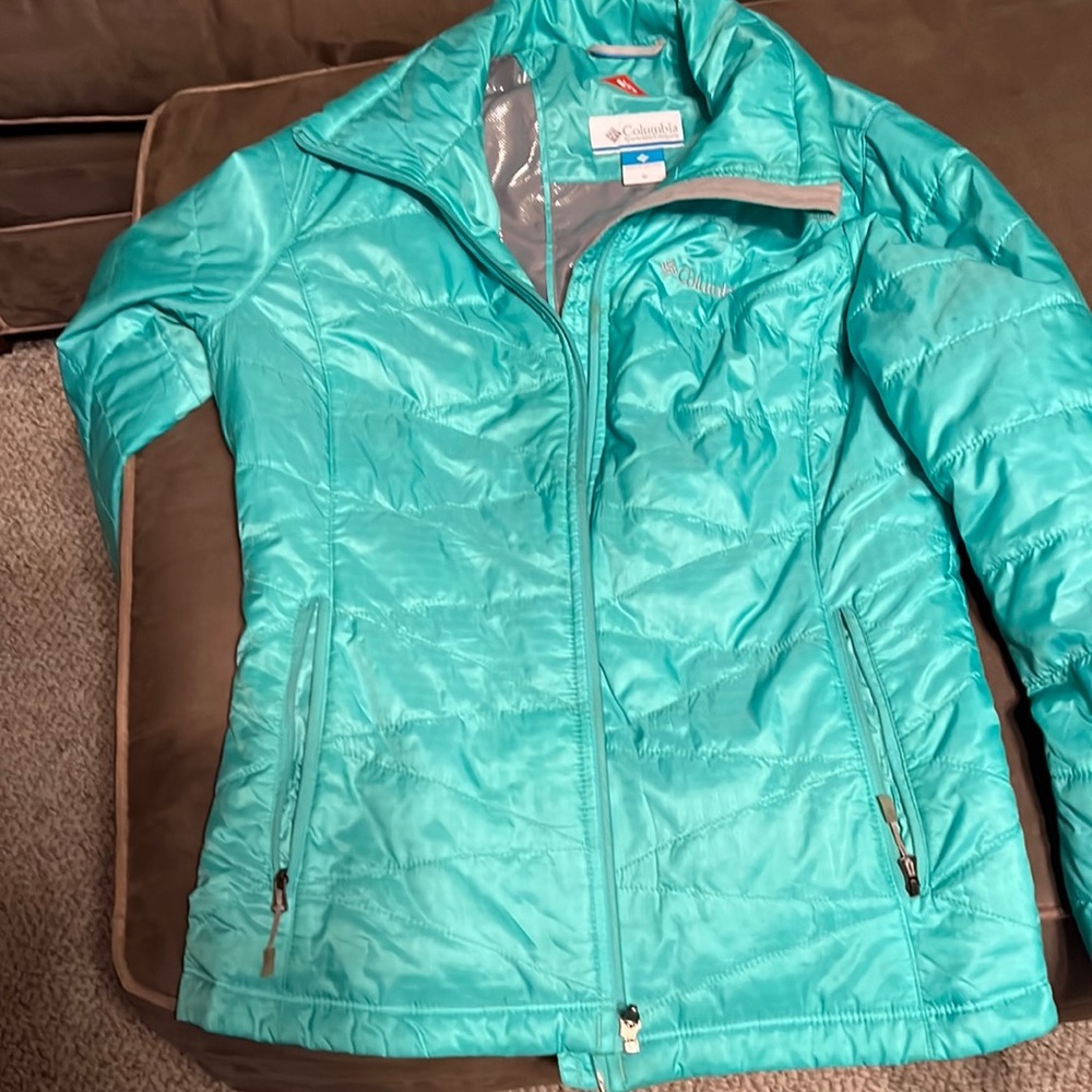 This a turquoise green Omni heat Columbia jacket. It hits at the waist.